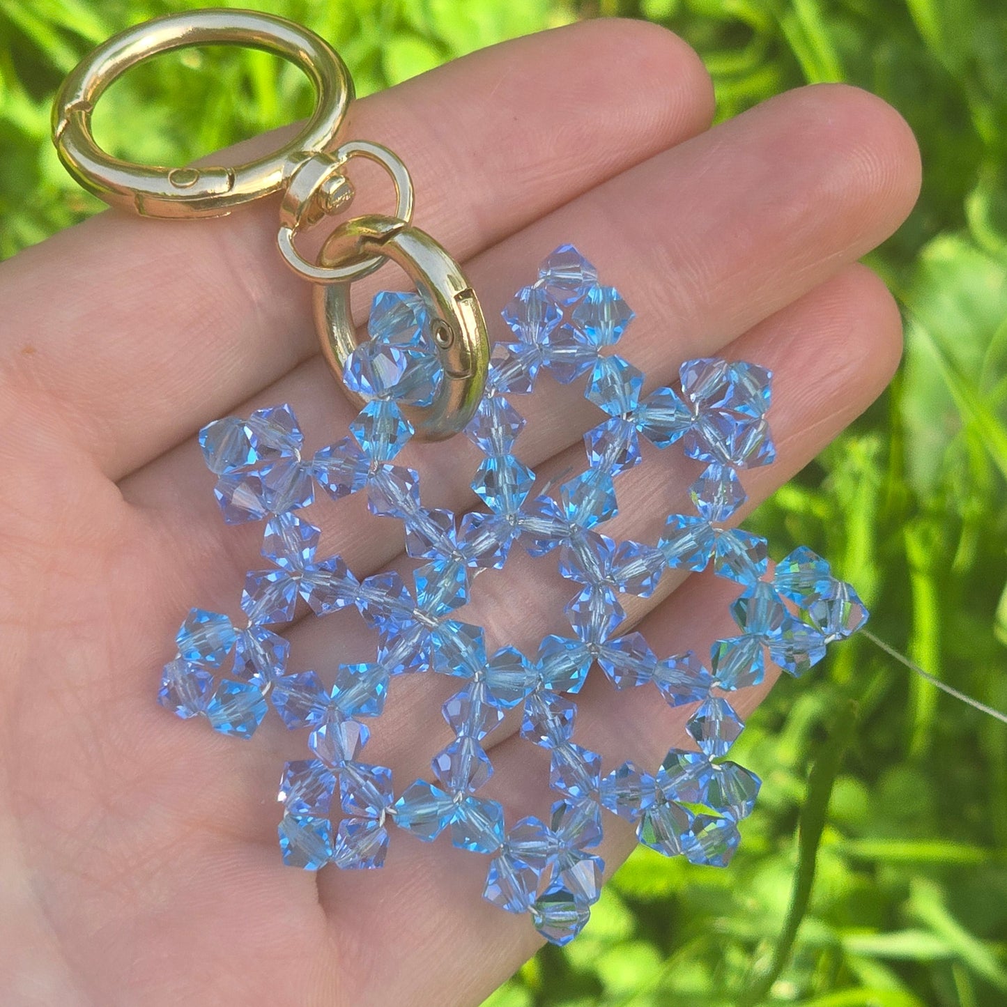 Luxury Austrian crystal snowflake bag charm handcrafted by Sivona attached to black leather handbag.Handmade crystal snowflake keychain with gold hardware and brilliant Austrian crystals.
Elegant snowflake purse charm featuring premium faceted Austrian crystals and designer craftsmanship.