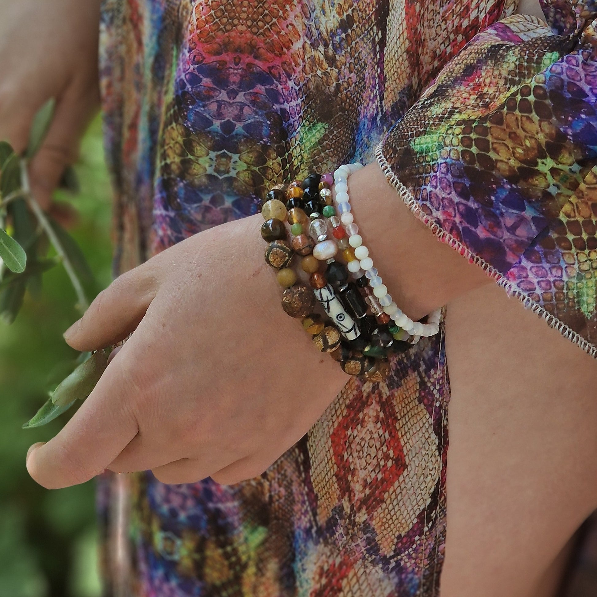 Detail of the Royal Topaz & Sapphire bracelet on a graceful arm, displaying blue topaz, sapphire, black tourmaline, natural pearl and black onyx accents