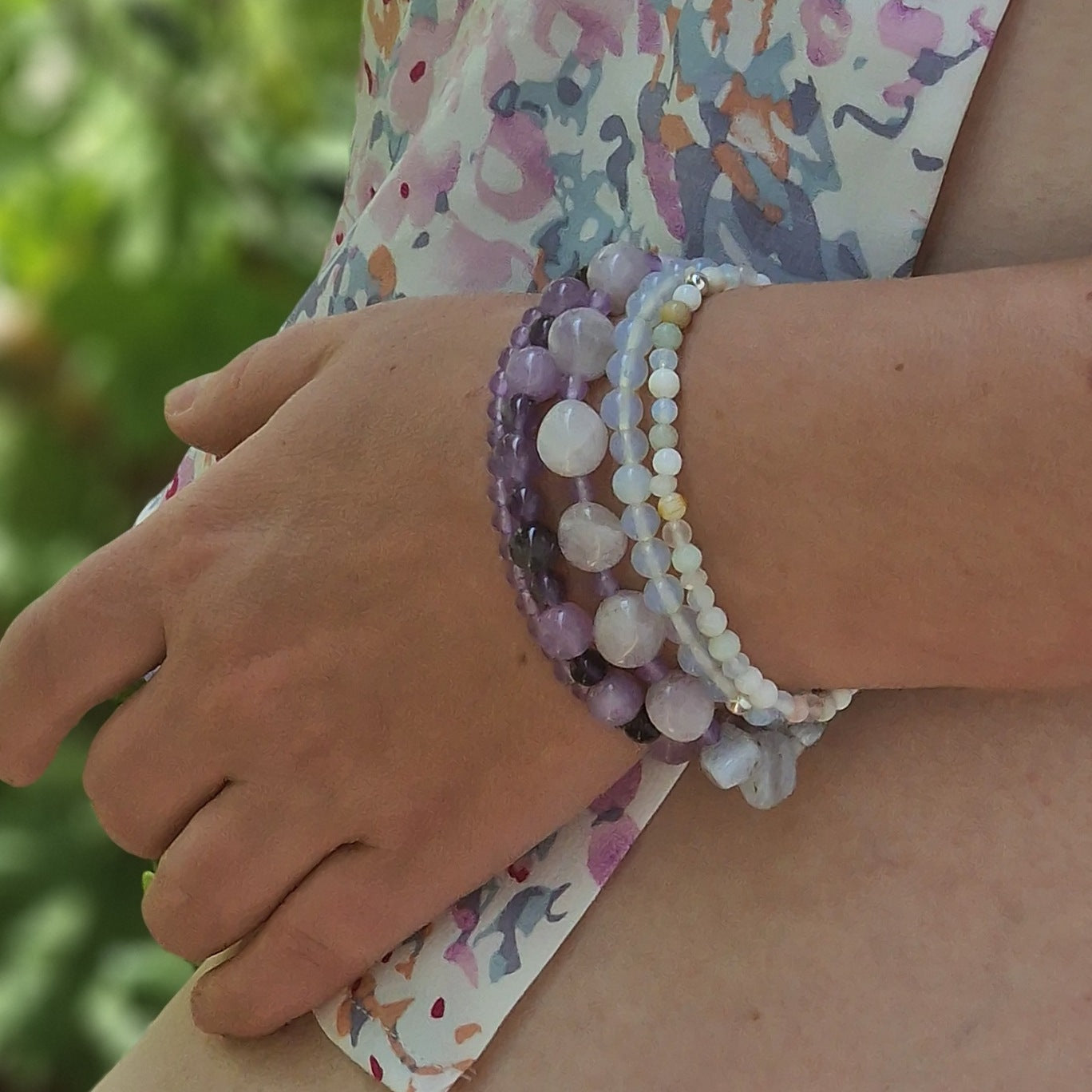 Close-up of hand wearing the Madagascar Jade & Amethyst 5-bracelet set against a neutral background