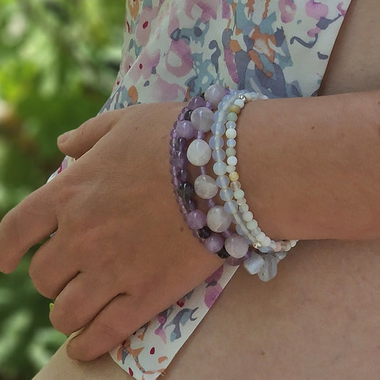 Close-up of hand wearing the Madagascar Jade & Amethyst 5-bracelet set against a neutral background