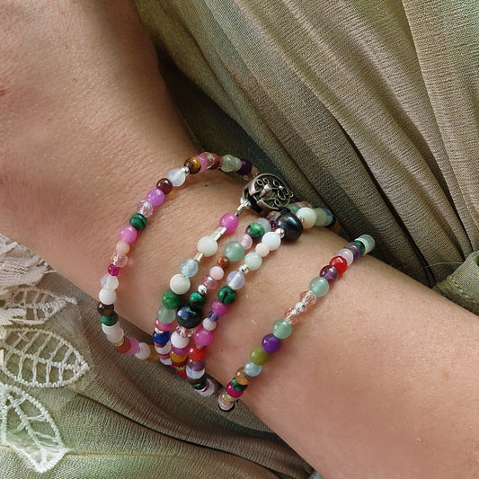 A 90 cm five-wrap gemstone wrap bracelet featuring agate, amethyst, rose quartz, tourmaline, jadeite and other healing stones, worn on a woman’s wrist with sterling silver clasp