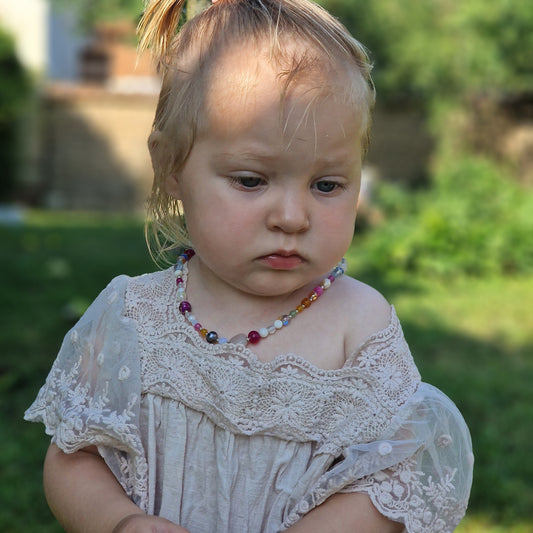 A delicate 45 cm girls’ gemstone necklace named Leonor, showcasing freshwater pearls, agate, rose quartz, clear quartz, moonstone, and tourmaline with a sterling silver clasp on a neutral background