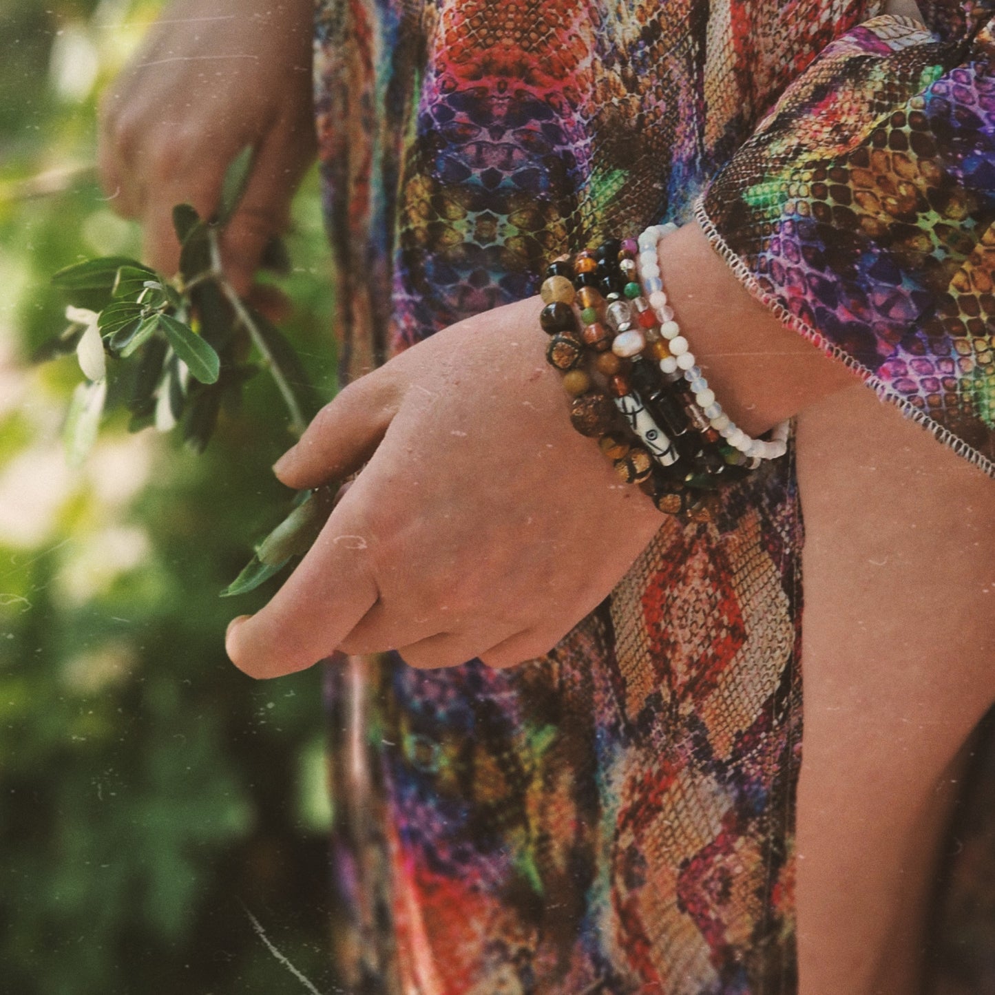 Elegant hand model showcasing the Zen Harmony bracelet from Anri Zenya set, with malachite, unakite, onyx, agate, carnelian, amethyst, and quartz beads