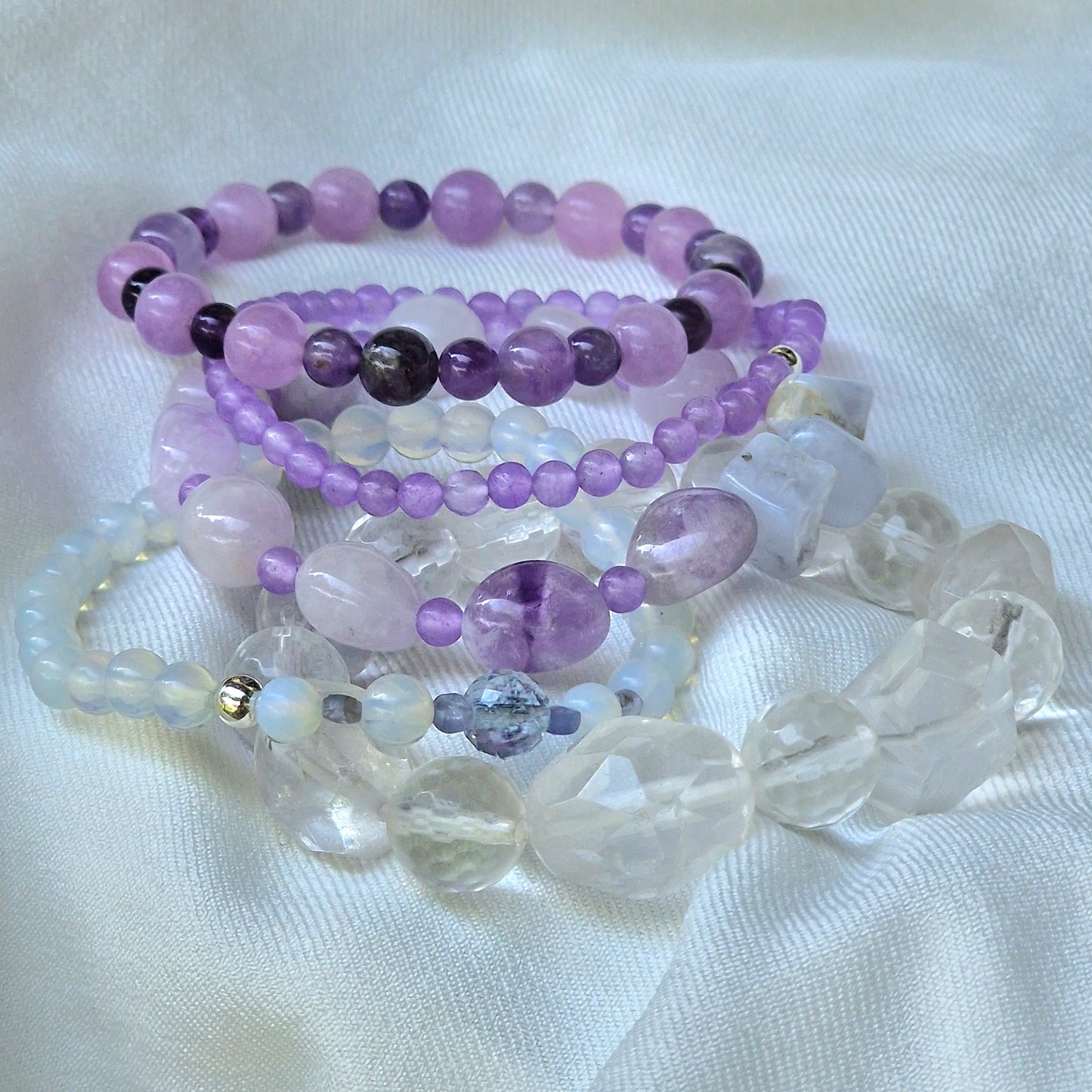 Anremo Azar five‑bracelet set featuring Himalayan quartz, pale lavender jadeite, jadeite & aquamarine mix, moonstone‑topaz‑tanzanite blend, and amethyst harmony bracelets