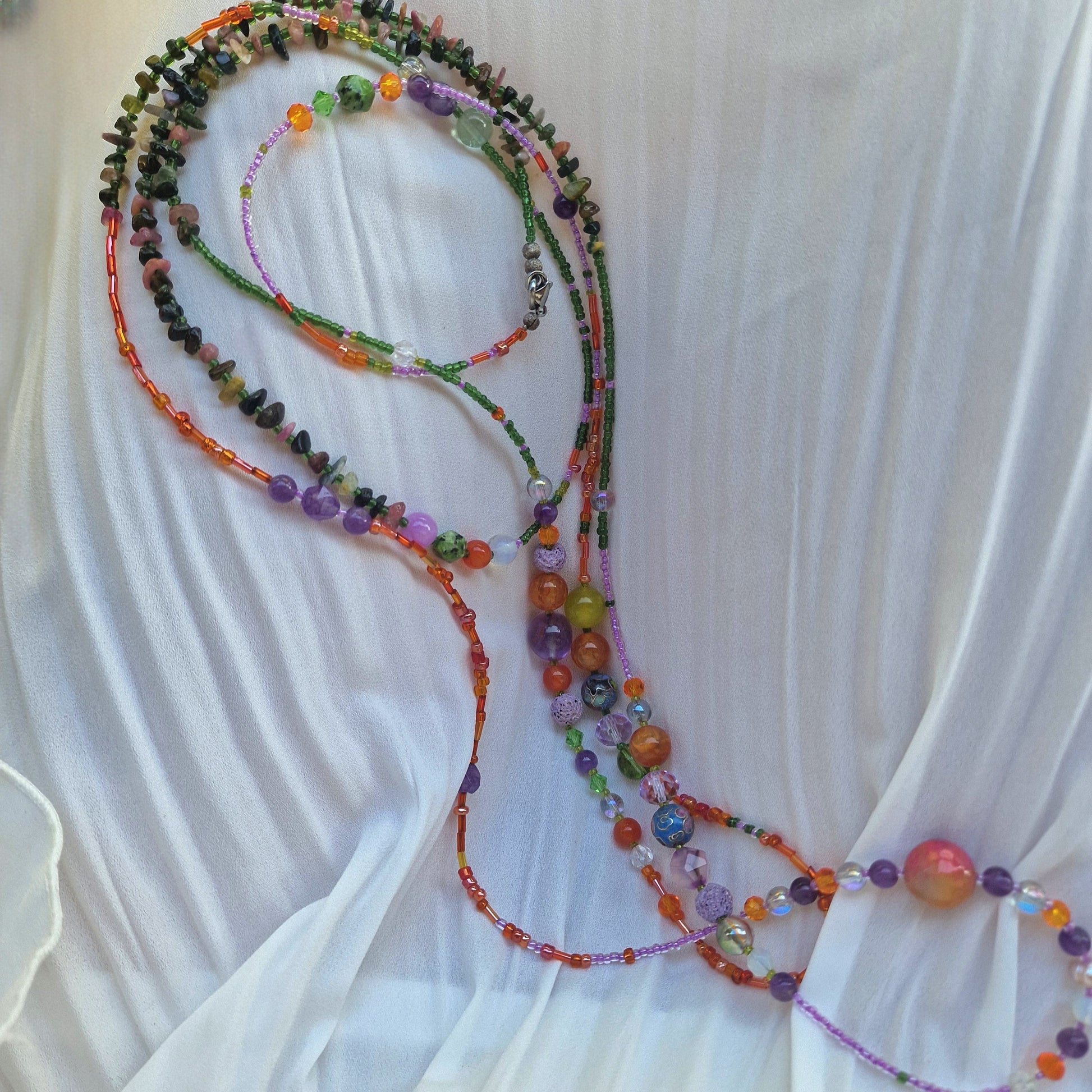A 188 cm multi-stone wrap necklace draped around a woman’s neck, showcasing agate, amethyst, tourmaline, rose quartz, jadeite, peridot, moonstone, opalite and sunstone beads