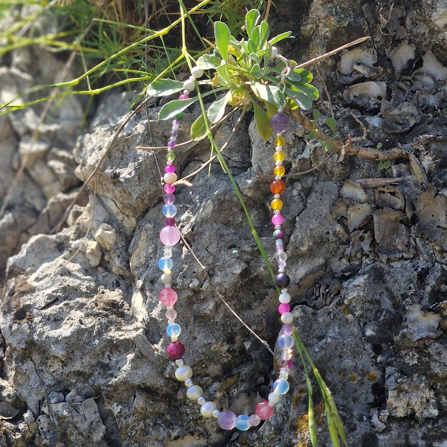 A 39 cm gemstone necklace for girls displayed on a pastel background, showcasing freshwater pearls, ruby, rose quartz, agate, jadeite, moonstone, carnelian and crystal quartz with a sterling silver clasp