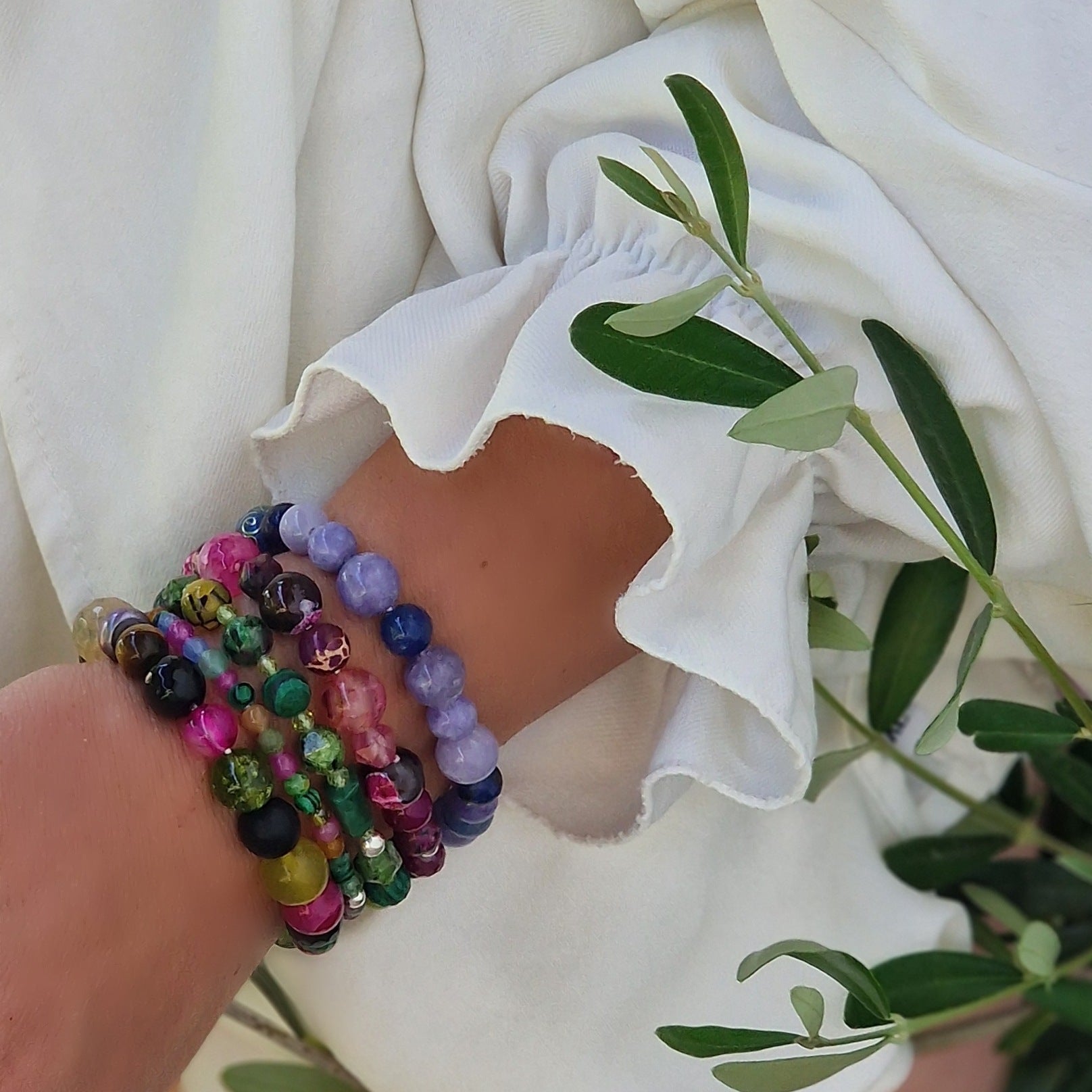 Close-up of a woman’s wrist showcasing the Jenove Amante Zen 5-bracelet set with variscite, azurite, peridot, tiger’s eye, onyx, malachite, black pearl, ruby zoisite and onyx beads