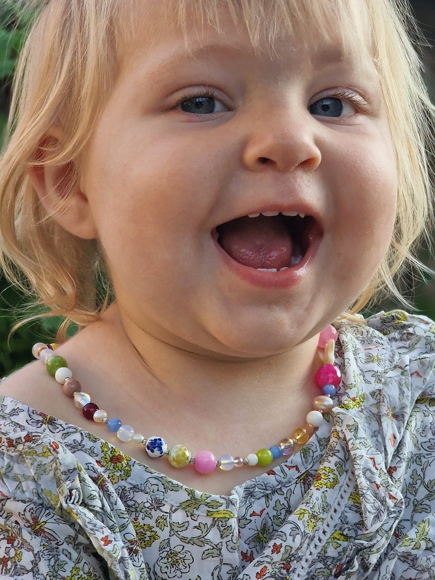 Side view of a blonde-haired girl showcasing the 45 cm gemstone necklace on elastic cord, accented by mother-of-pearl and moonstone beads