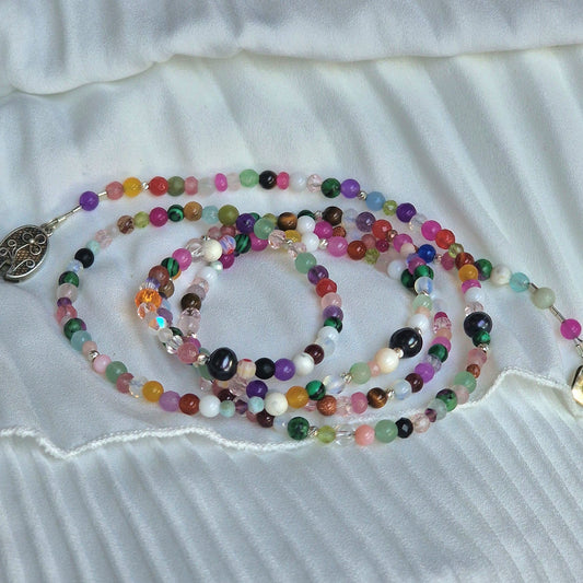 A versatile 5-wrap crystal energy bracelet on a woman’s wrist, showcasing Madagascar jadeite, amethyst, moonstone, agate and howlite beads